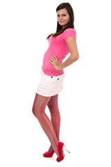 Teenage girl standing with hand on hip in pink clothes isolated