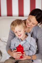 mutter und sohn mit brennender kerze