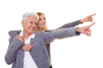 Seniorin und Enkelin zeigen mit Fingern
