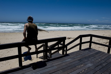 Fototapeta premium Guy sitting looking at ocean