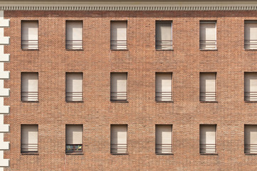 Red brick wall with white windows pattern.