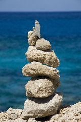 Fototapeta na wymiar Close-up of stone stack against blue sea