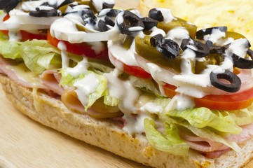 a sandwich with meat, vegetables and olives