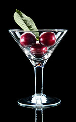 Three cherry and leaf in wine glass