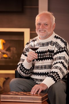 Portrait of happy senior man having wine