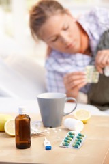 Obraz na płótnie Canvas Vitamins medicines for flu woman in background
