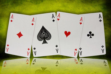 four aces with reflection on green background