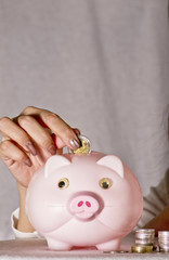 young woman with pink piggy bank