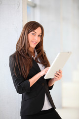 Businesswoman standing in hall with electronic pad
