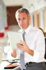 Fototapeta na wymiar Office worker looking at internet on electronic pad