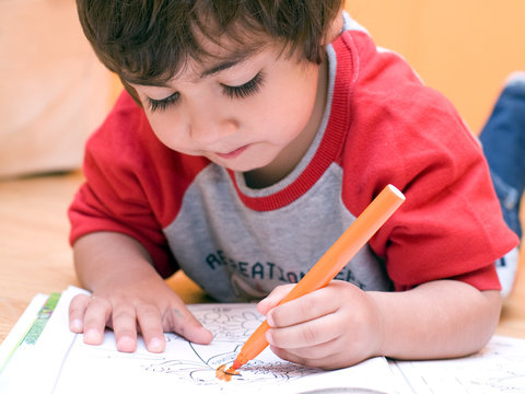 bambino che colora sul quaderno