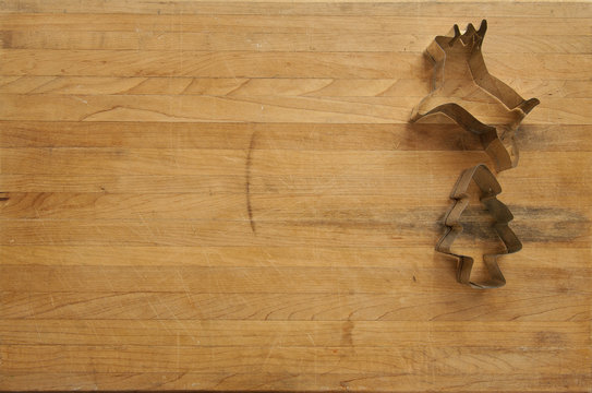 Reindeer and Christmas Tree Cookie Cutter on Worn Cutting Board
