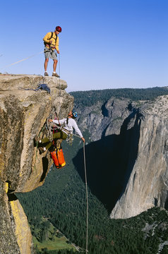 Rock climbing team reaching the summit.