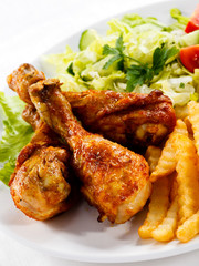 Grilled chicken drumsticks, chips and vegetables