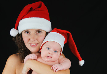 Beautiful mommy santa and her baby Santa boy on a black