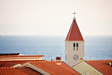 Fototapeta premium Chatolic church over roofs at sea.