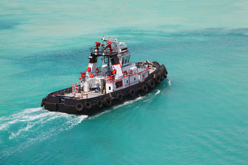 Pilot on little fire pusher tug drift through the sea at day