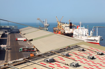 Working people ship cargo boats at the Abu Dhabi industrial port