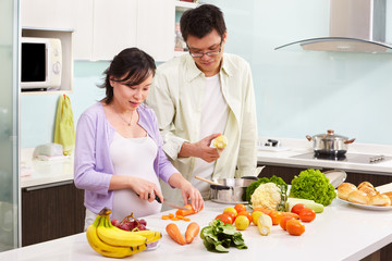 Obraz na płótnie Canvas Asian couple busy in kitchen
