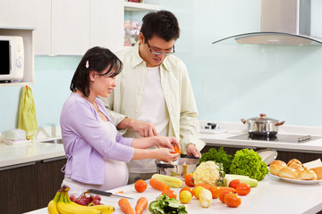 Asian couple busy in kitchen