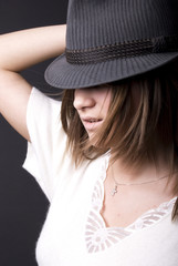Portrait of a young fashionable brunette in hat .