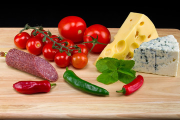 White and yellow cheese with salami and vegetables