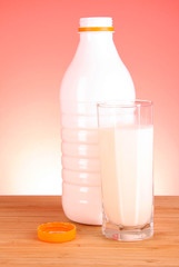 Bottle of milk and glass on red background