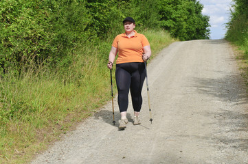 XXL-Model übergewichtige Frau beim Nordic Walking