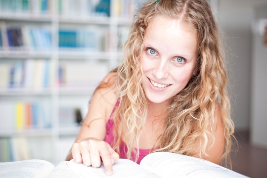 pretty female college student in a library (shallow DOF; color t