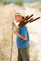 Child playing with bulrush