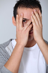 Closeup of young man hiding face whit hands