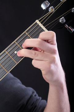 Human hand taking  D-minor accord at guitar