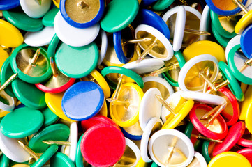 Many colourful office pins on the background