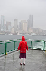 Young girl on boat looking towards city skyline