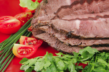 beef on red plate over white