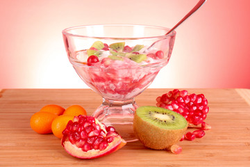 some coctail with fruits in glass with spoon on red background