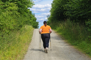 XXL-Model übergewichtige Frau beim Nordic Walking