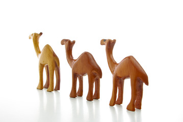 Three wooden camels isolated on a white background