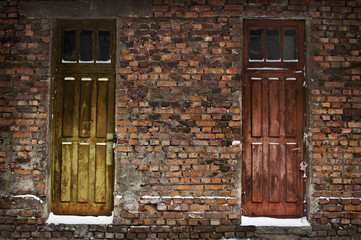Two old wooden doors in brick wall