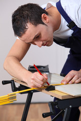 Young man working wood on workbench