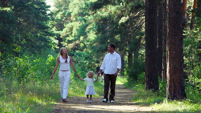 Family of three walking on the trail in summertime