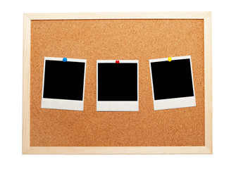 Blank instant photos on a corkboard