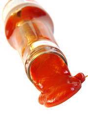 Tasty ketchup flowing out of the bottle isolated