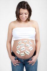 Happy woman is looking on her baby tummy full with names