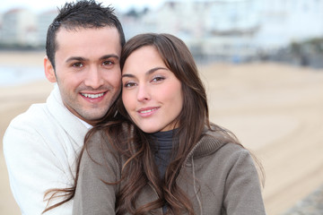 Obraz premium Young couple spending a week-end at the beach in winter