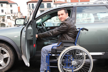 Fototapeta na wymiar Młody człowiek w wózku miejsce w swoim samochodzie