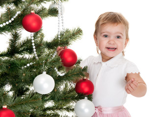 Happy little girl decorating a christmas tree