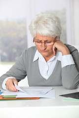 Elderly woman having trouble filling in paperwork