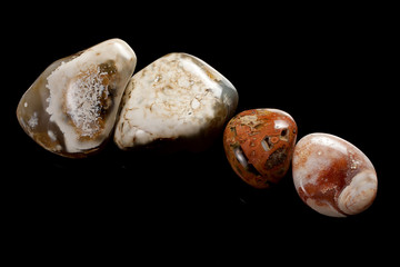 four semiprecious stones on black background