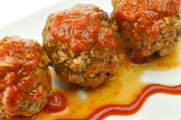 meat balls with tomato sauce on white dish close up